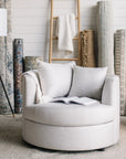 Gray cuddle chair with a book in a room with decorative rugs and a lamp in St. Albert, Alberta
