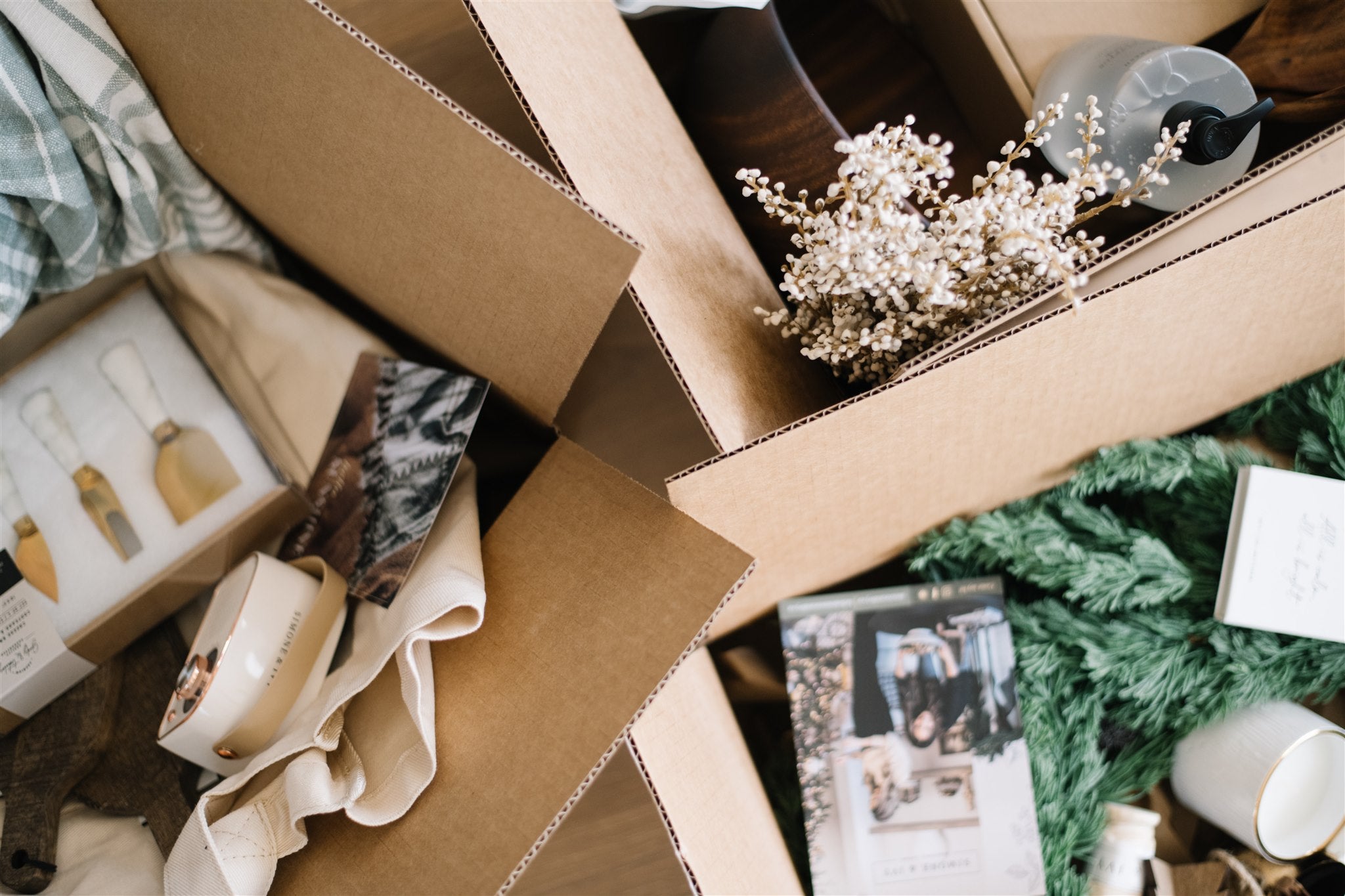 Open cardboard box with various items including a plant, photo album, and decorative objects.